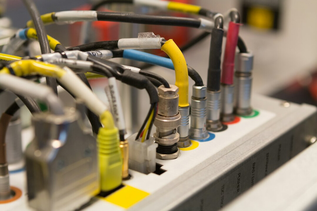 Rack of broadcast equipment with cables and indicator lights